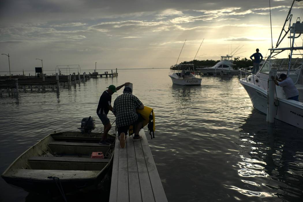 People arrive to a private harbor to move boats away for protection ahead of the arrival of Hur ...