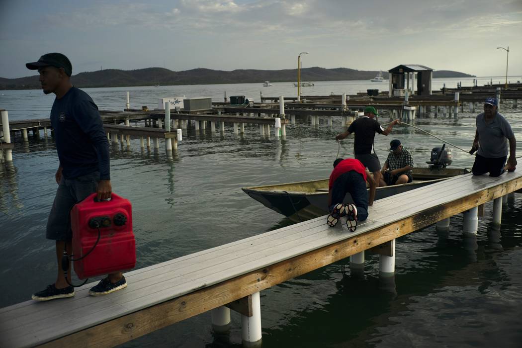 People arrive to a private harbor to move boats away for protection ahead of the arrival of Hur ...