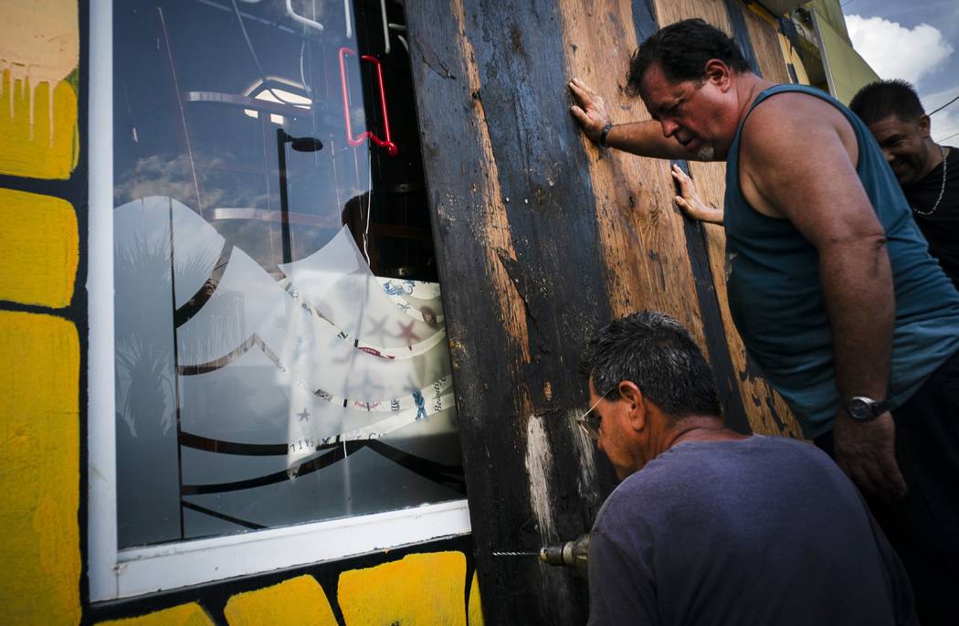 Men board up a shop's windows ahead of the arrival of Hurricane Dorian in Boqueron, Puerto Rico ...