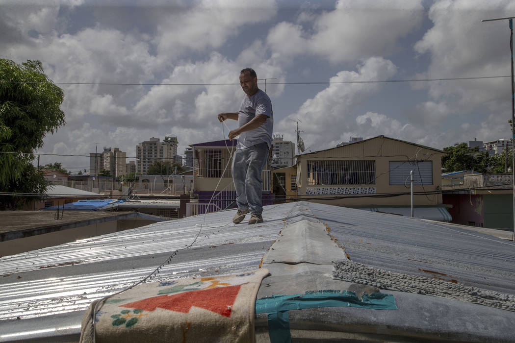Jorge Ortiz works to tie down his roof as he prepares for the arrival of Hurricane Dorian in th ...