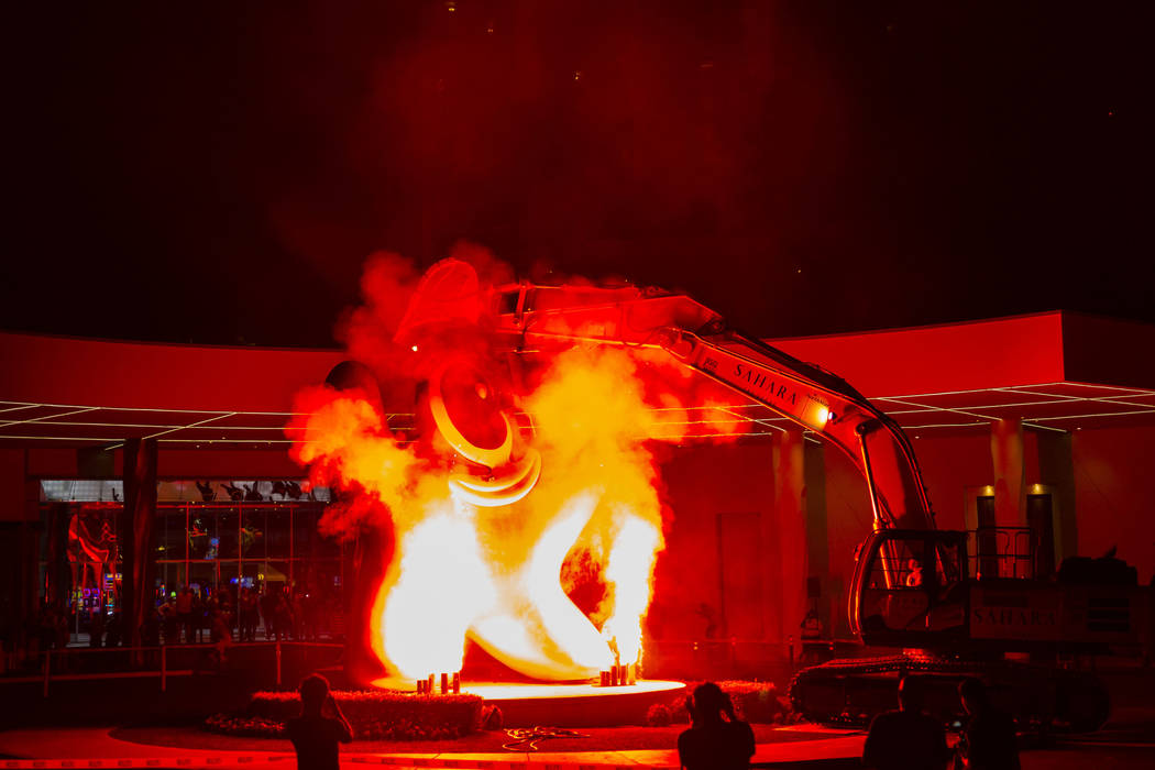 Flames shoot into the air prior to the removal of the "Sam by Starck" statue at the S ...