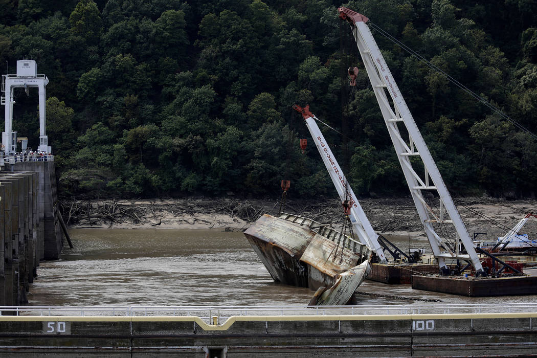 One of two sunken barges is removed from the Webbers Falls Lock and Dam 16 Tuesday, Aug. 27, 20 ...