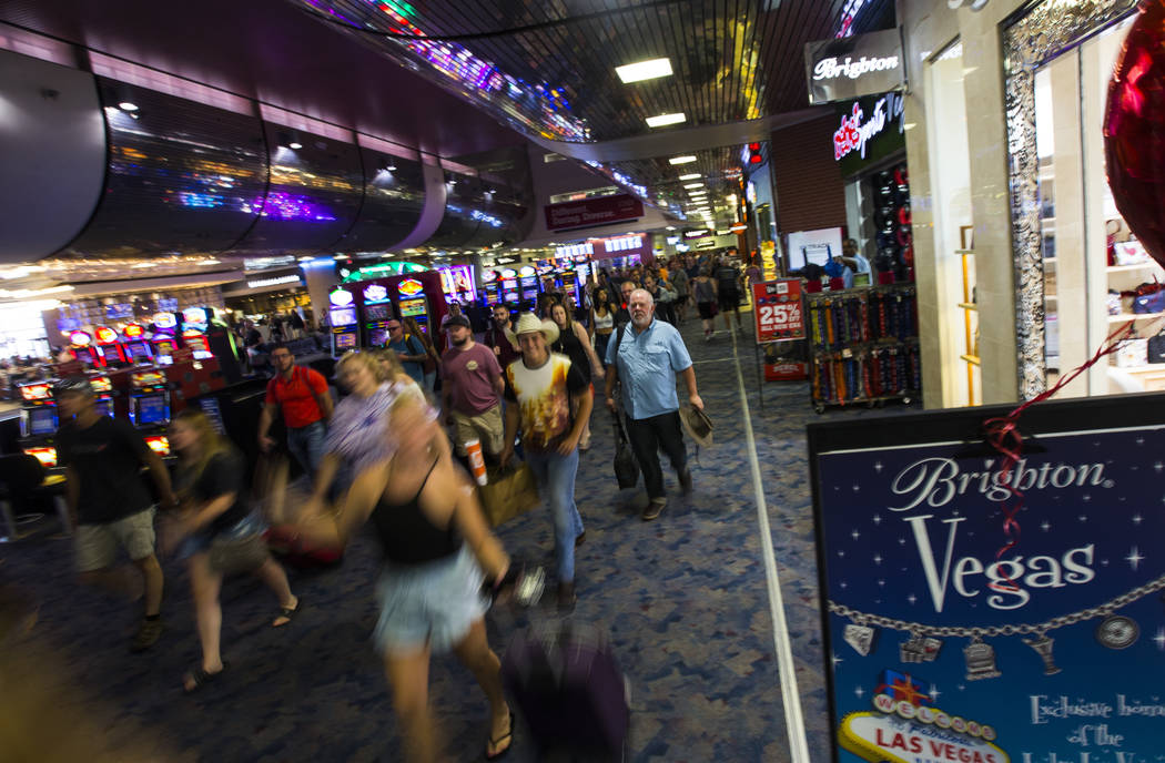 Passengers make their way to baggage claim and transportation at McCarran International Airport ...