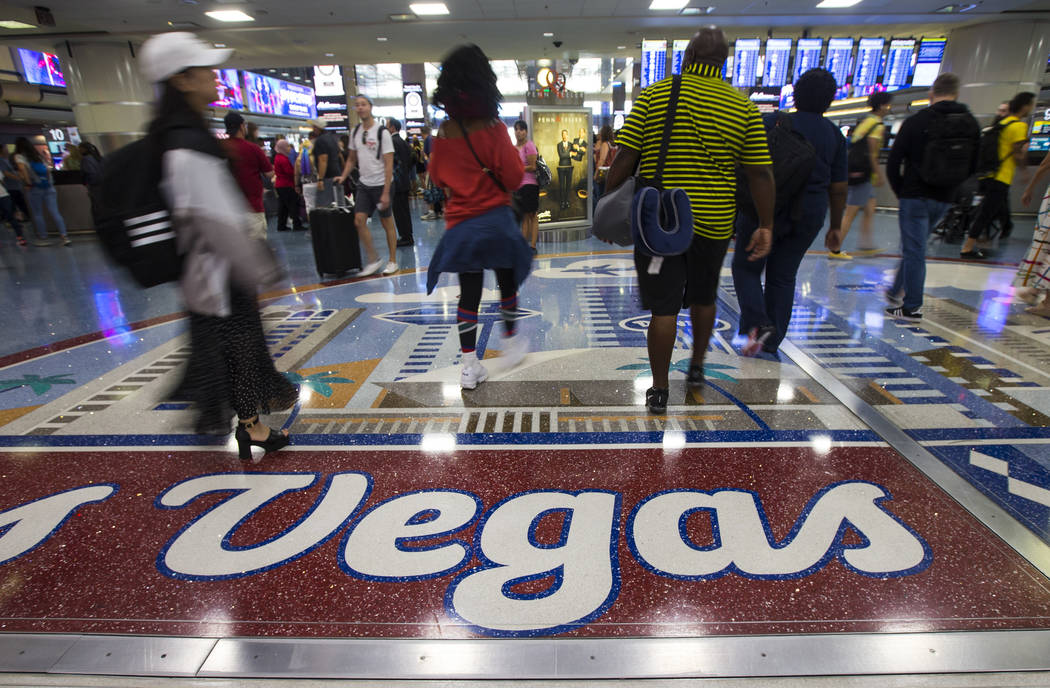 Passengers walk around the baggage claim area at McCarran International Airport ahead of the La ...