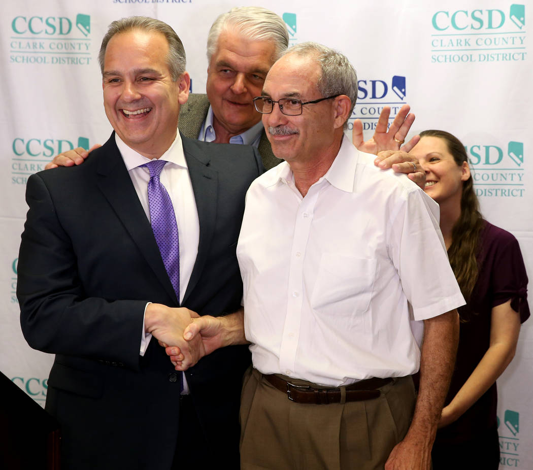 Gov. Steve Sisolak, center, prods Clark County School District Superintendent Jesus Jara, left, ...