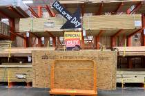 A shopper stands with a dolly of plywood at The Home Depot ahead of Hurricane Dorian on Thursda ...