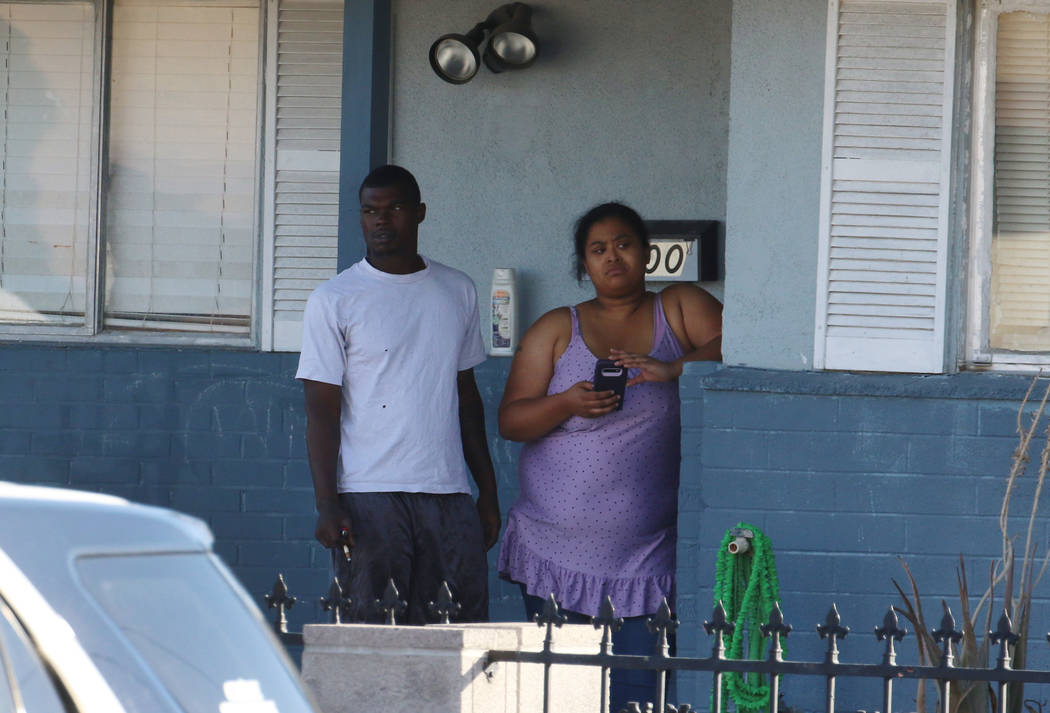 Residents watch as Las Vegas police investigate the killing of a woman on the 1000 block of Nor ...