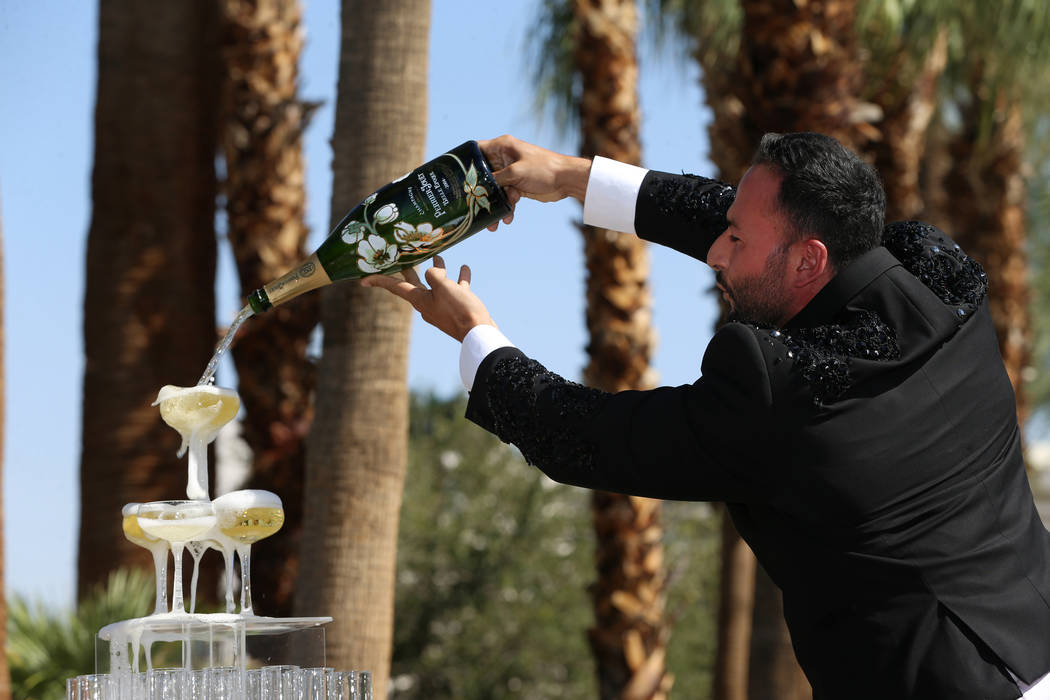 Monsieur Romeo, cast member for Blanc de Blanc, pours champagne during a rebranding event for S ...