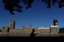A pedestrian passes Britain's Houses of Parliament on the bank of The River Thames in London, T ...