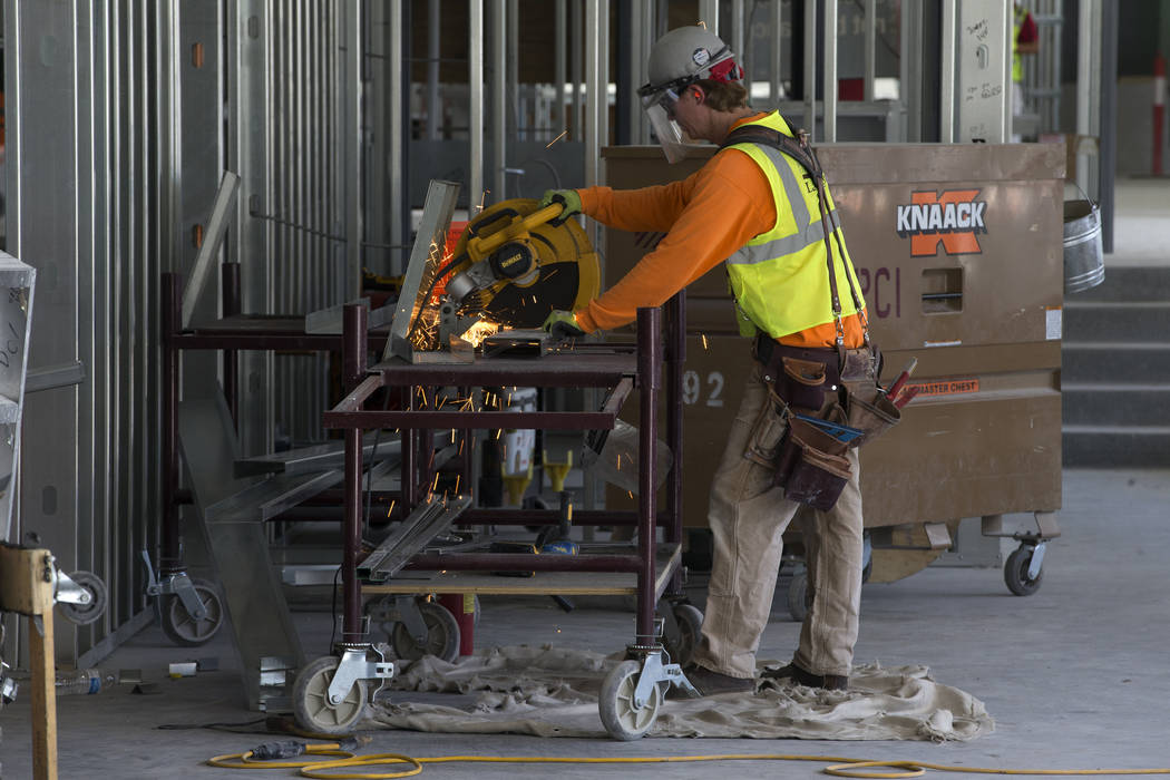 A worker cuts a piece of metal at the Raiders Allegiant Stadium construction site in Las Vegas, ...