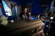 Vanessa Galindo Blas, 32, places a rose on a photograph atop the coffin of her late husband Eri ...