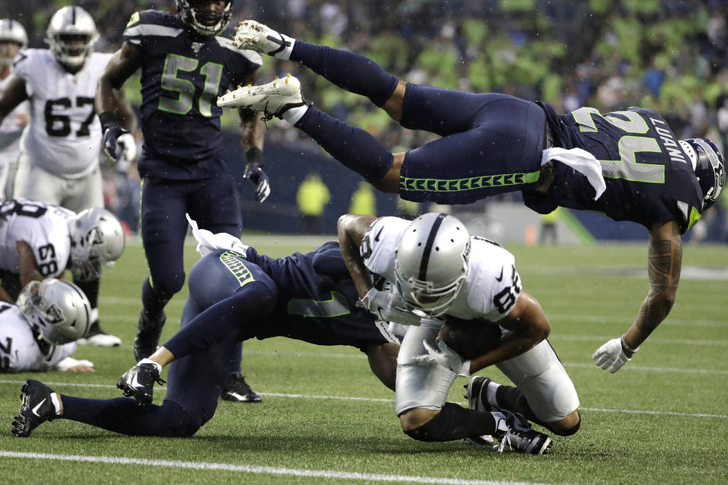 Seattle Seahawks defensive back Shalom Luani (24) flies over Oakland Raiders wide receiver Marc ...