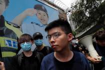 FILE--Pro-democracy activist Joshua Wong, foreground, joins other protesters to surround the po ...