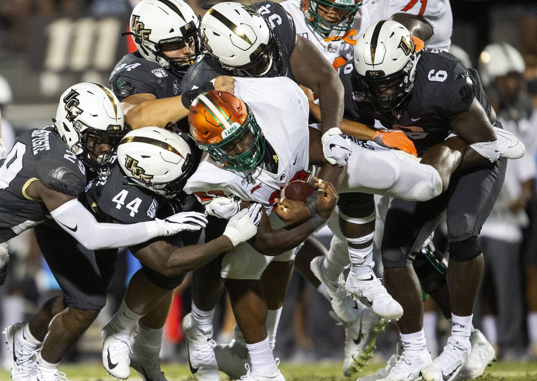 Florida A&M running back Terrell Jennings (23) is lifted off the ground and tackled by five ...