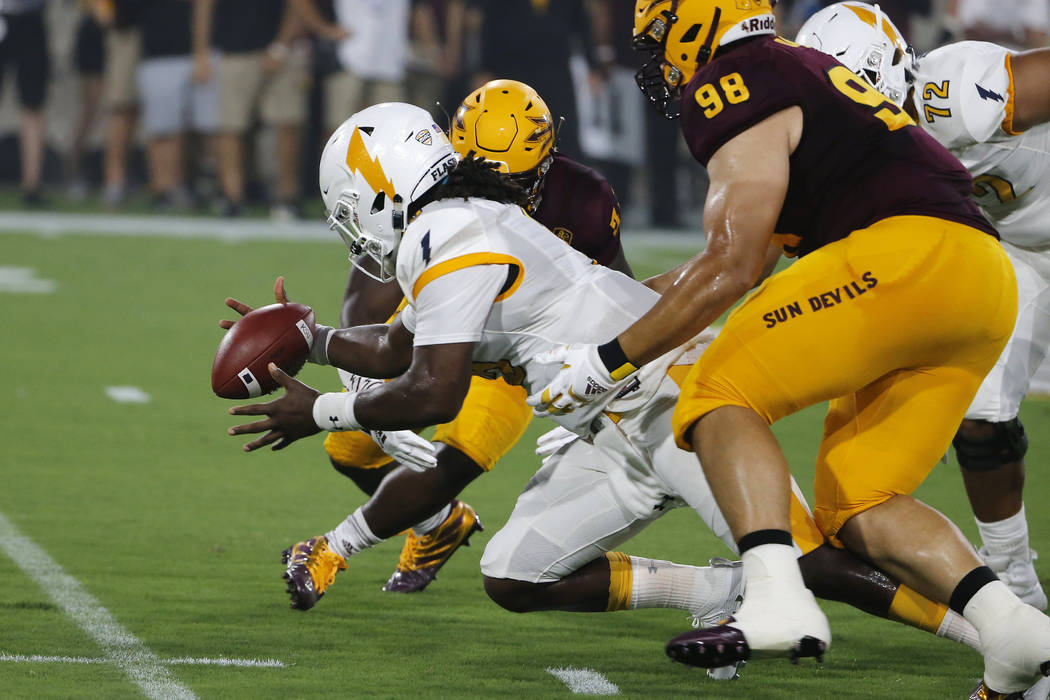 Kent State quarterback Woody Barrett, center, recovers his own fumble in front of Arizona State ...