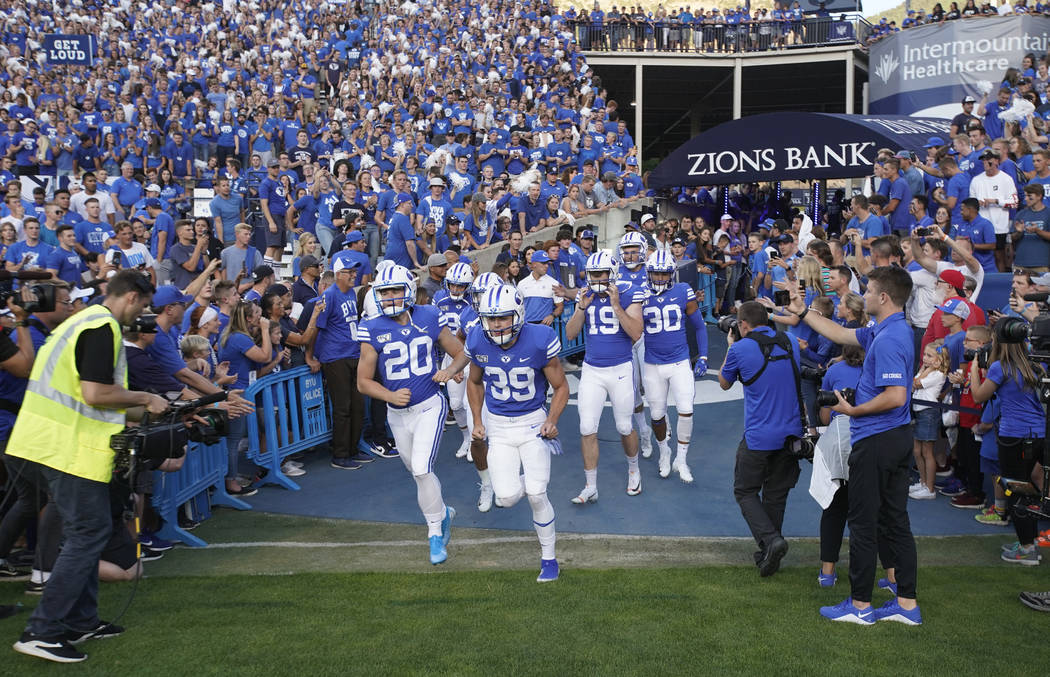 BYU football players enter the field to warm up for an NCAA college football game against Utah, ...