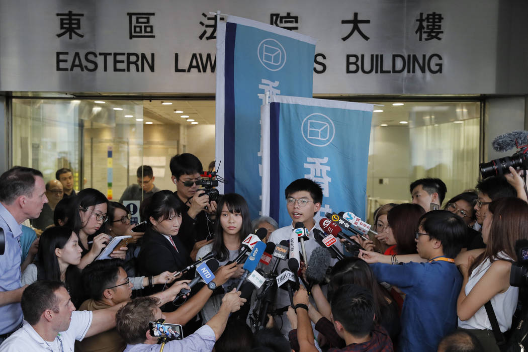 Pro-democracy activists Joshua Wong, right, and Agnes Chow speak to media outside a district co ...