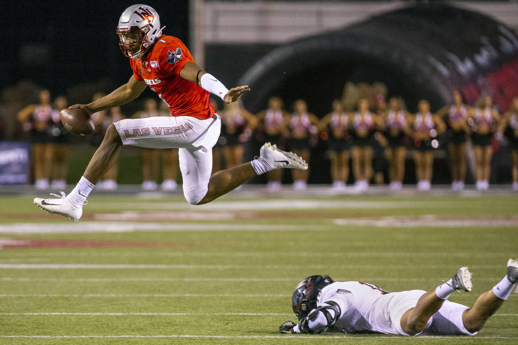 UNLV Rebels quarterback Armani Rogers (1) leaps over a tackle attempt by Southern Utah Thunderb ...