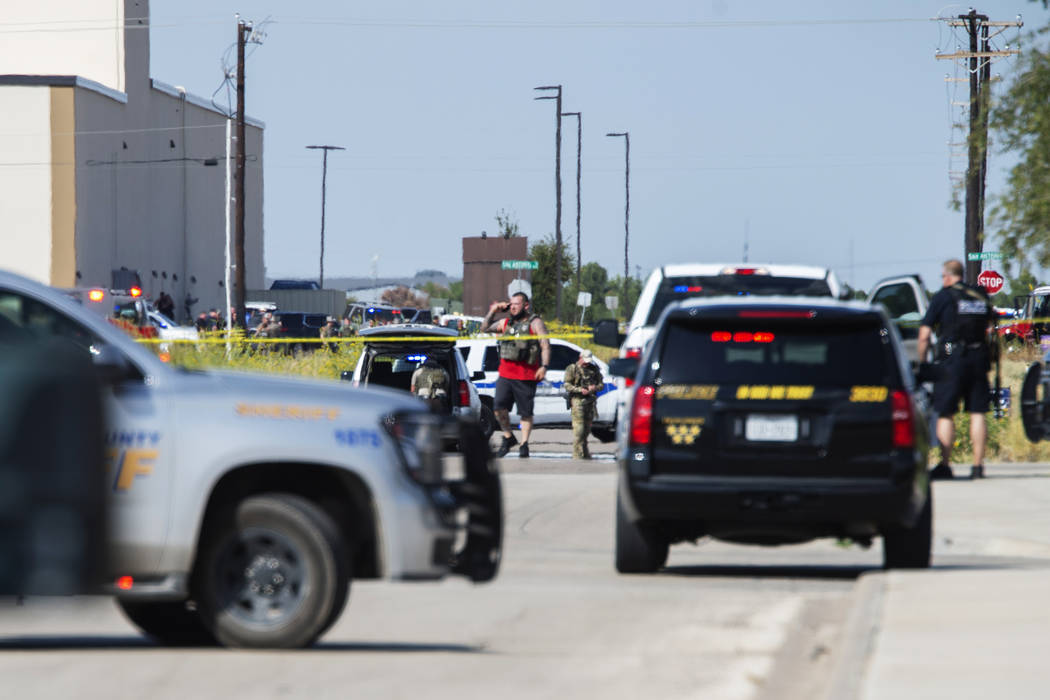 Odessa and Midland police and sheriff's deputies surround the area behind Cinergy in Odessa, Te ...