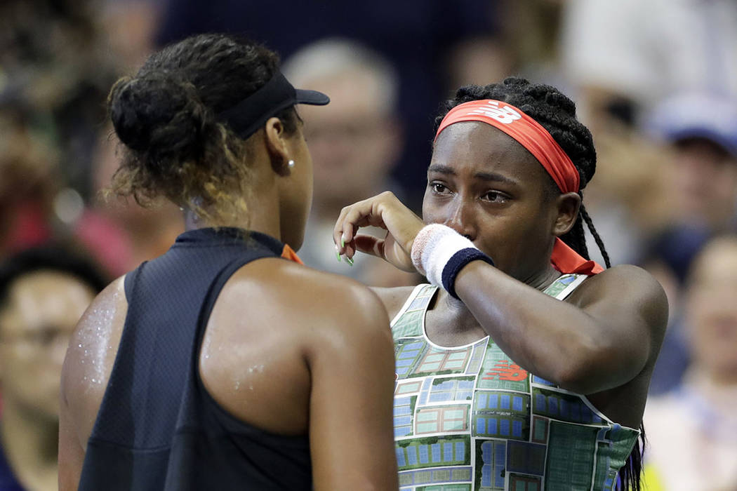 Coco Gauff, right, of the United States, wipes away tears while talking to Naomi Osaka, of Japa ...