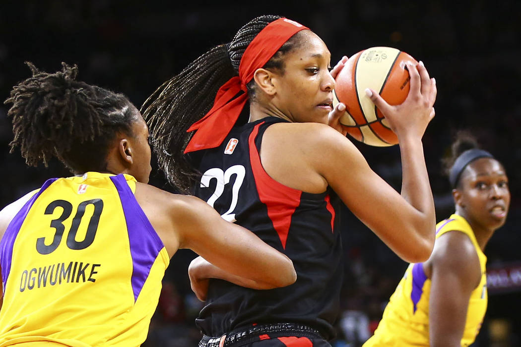 Las Vegas Aces' A'ja Wilson (22) moves the ball around Los Angeles Sparks' Nneka Ogwumike (30) ...