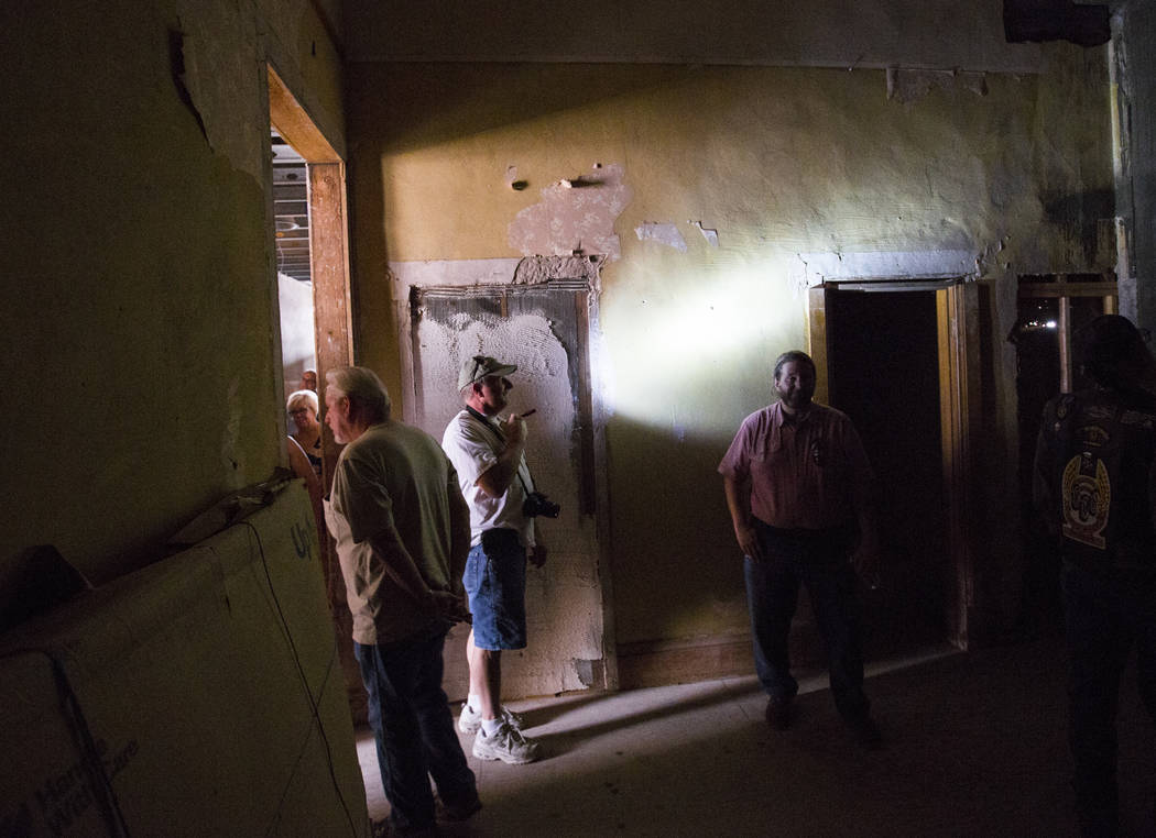 Steve Helt of Las Vegas, center, shines a flashlight while touring the Goldfield Hotel during t ...