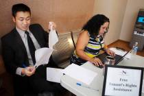 Nevada Legal Services Attorney Ron Sung, left, looks over eviction processing paperwork as para ...