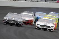 Kevin Harvick, left, and Brad Keselowski, right, drive through the first turn during the NASCAR ...