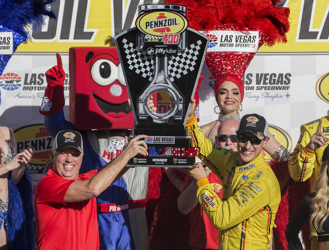 Joey Logano, right, and Carlos Maurer, president of Shell Lubricants Americas, hold the first p ...