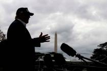 With cloudy skies in Washington, President Donald Trump speaks to the media as he returns to th ...