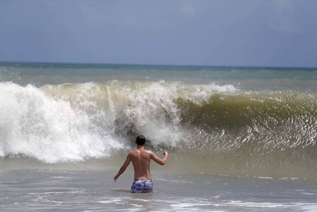 A person plays in the high surf form the Atlantic Ocean on the barrier island in Vero Beach, Fl ...