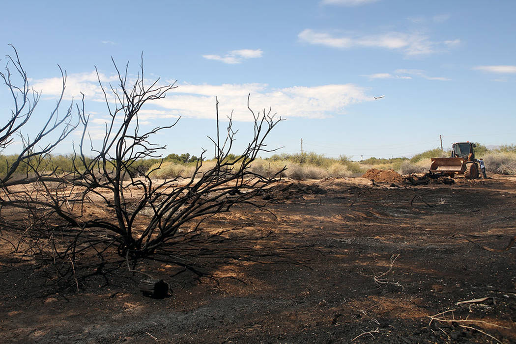 Crews work in the field after a brush fire at Sunset Park on Sunday, Sept. 1, 2019. (Michael Bl ...