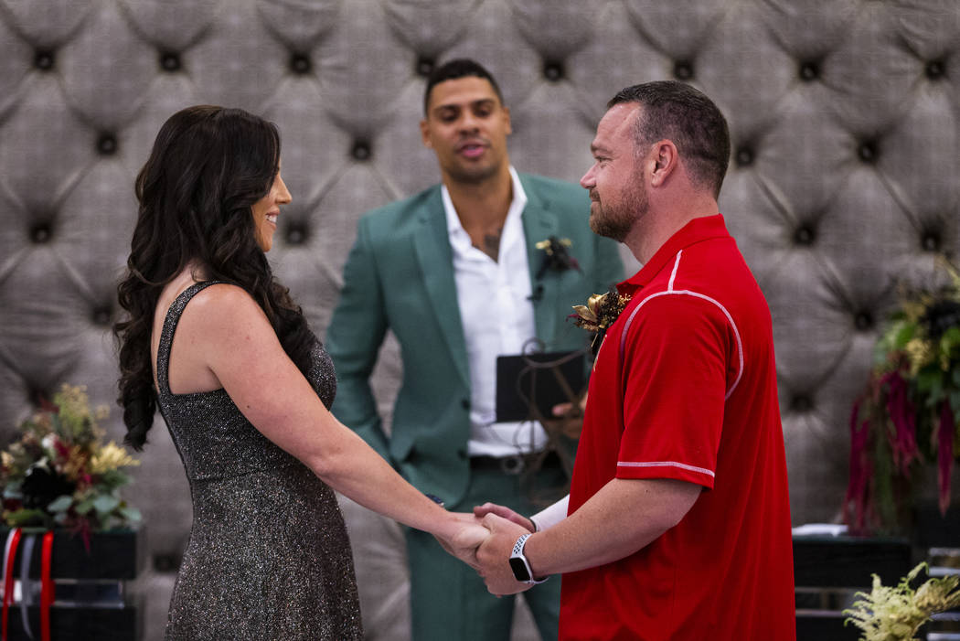 Laura and Justin Long hold hands as Vegas Golden Knights player Ryan Reaves, center, conducts a ...