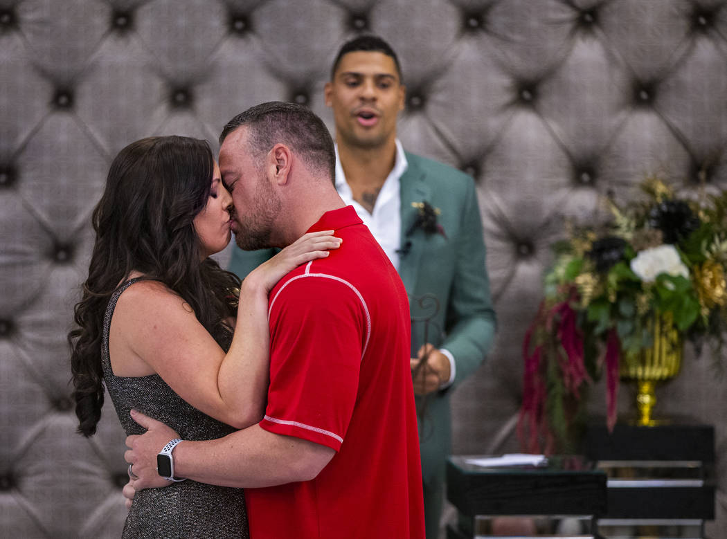 (From left) Laura and Justin Long kiss as Vegas Golden Knights player Ryan Reaves finishes cond ...