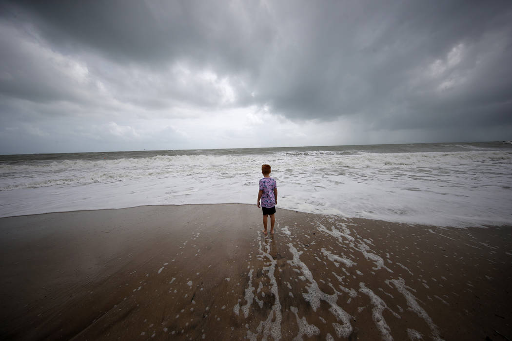 Weston Lee, of Vero Beach, stands near the high surf from the Atlantic Ocean, in advance of the ...
