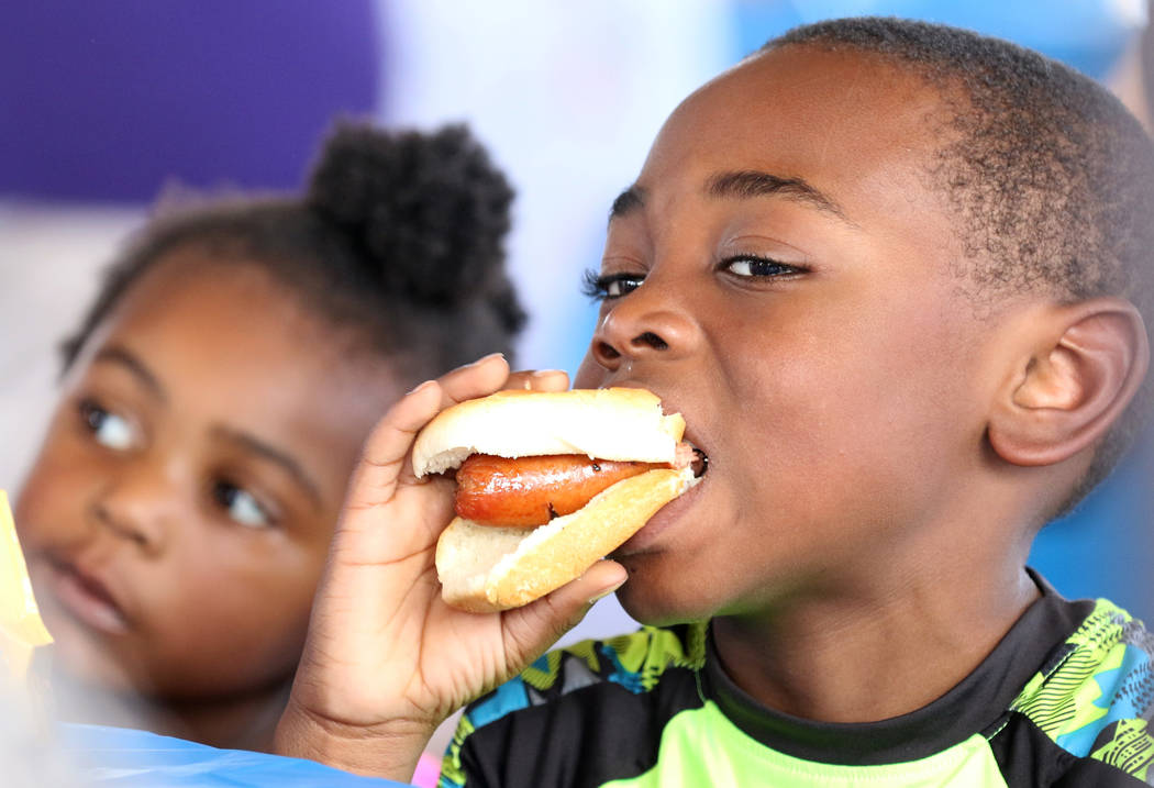Samir Carter, 6, enjoys his hotdog as his sister Saffiyyah Wilson, 3, looks on at Rep. Steven H ...