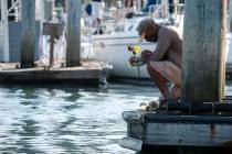 James Miranda, right, of Santa Barbara, holds flowers and takes a moment to reflect at a dock n ...