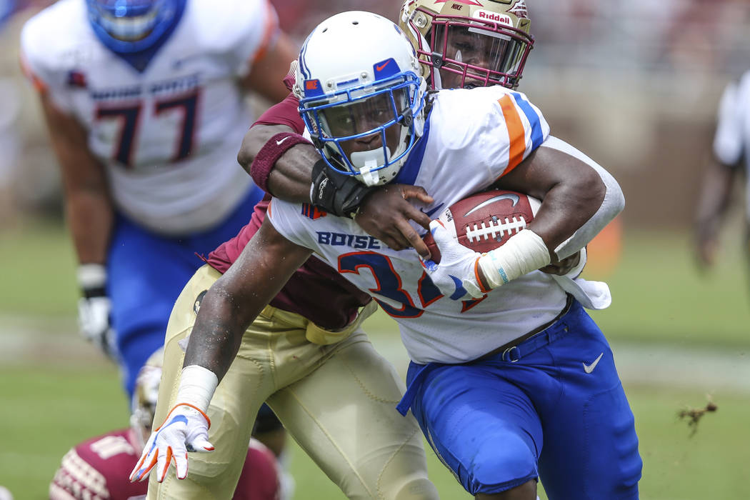 Boise State running back Robert Mahone (34) is tackled by Florida State linebacker Decalon Broo ...