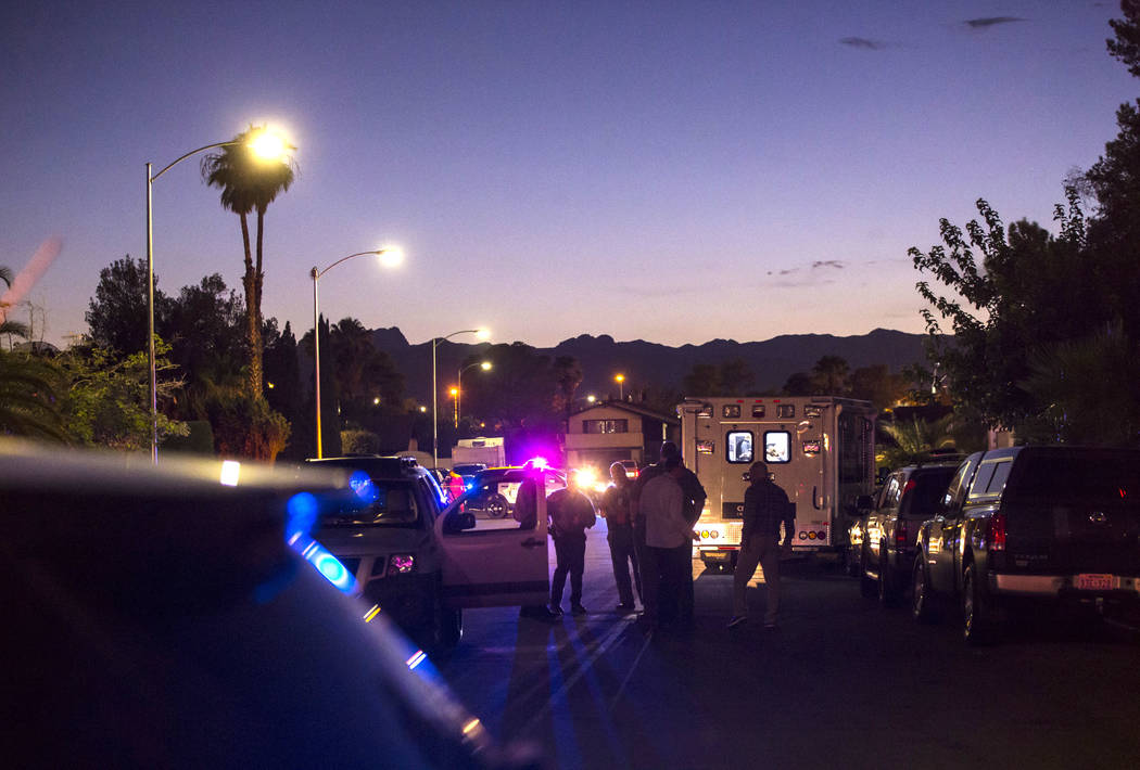 Las Vegas police secure the area around a residential street as they wait for a search warrant ...