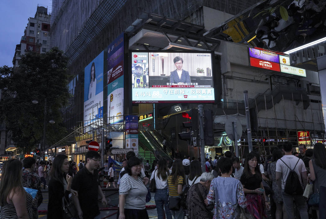 People watch telecast that Hong Kong Chief Executive Carrie Lam makes an announcement on an ext ...