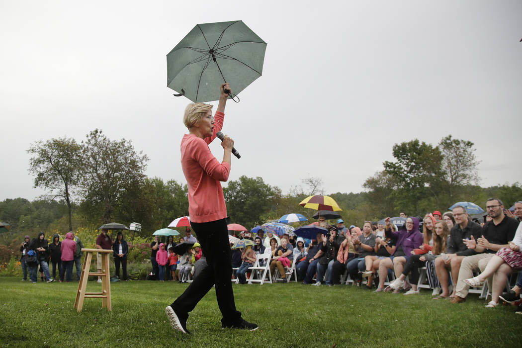 Democratic presidential candidate Sen. Elizabeth Warren, D-Mass., gestures with an umbrella as ...