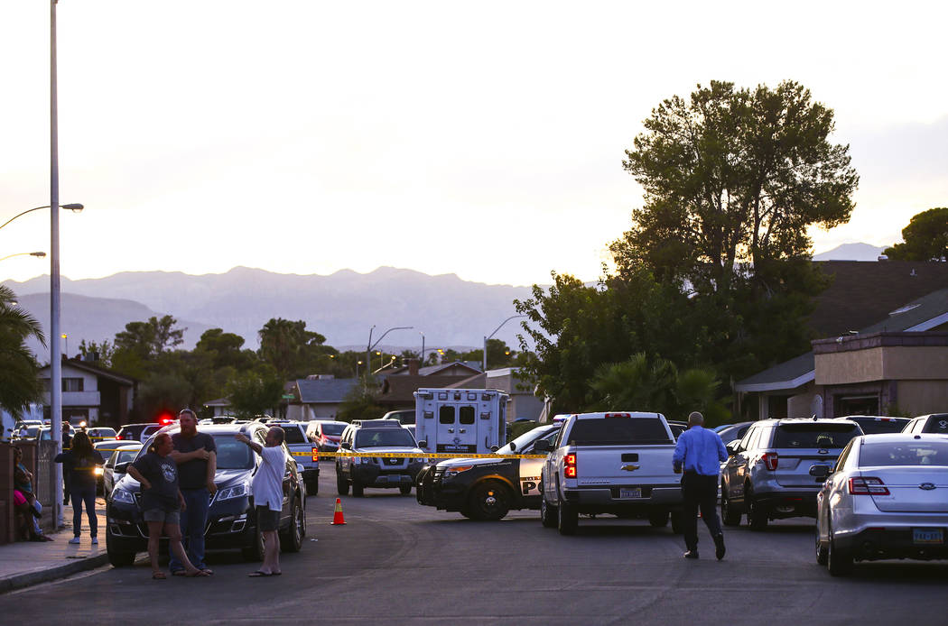 Las Vegas police secure the area around a residential street as they wait for a search warrant ...