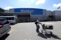 A customer pushes a shopping cart Tuesday, Sept. 3, 2019, outside a Walmart store, in Walpole, ...