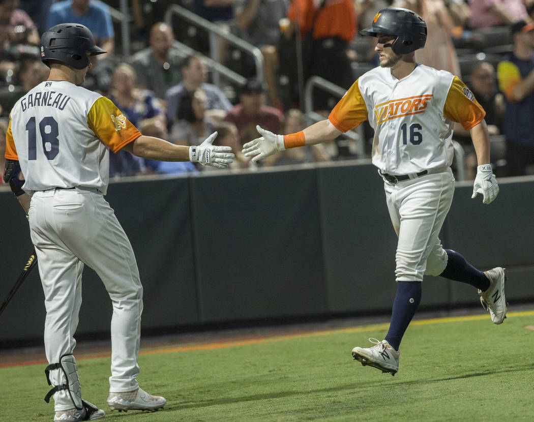 Las Vegas Aviators left fielder Mark Payton (16) gets a high five from Las Vegas Aviators catch ...