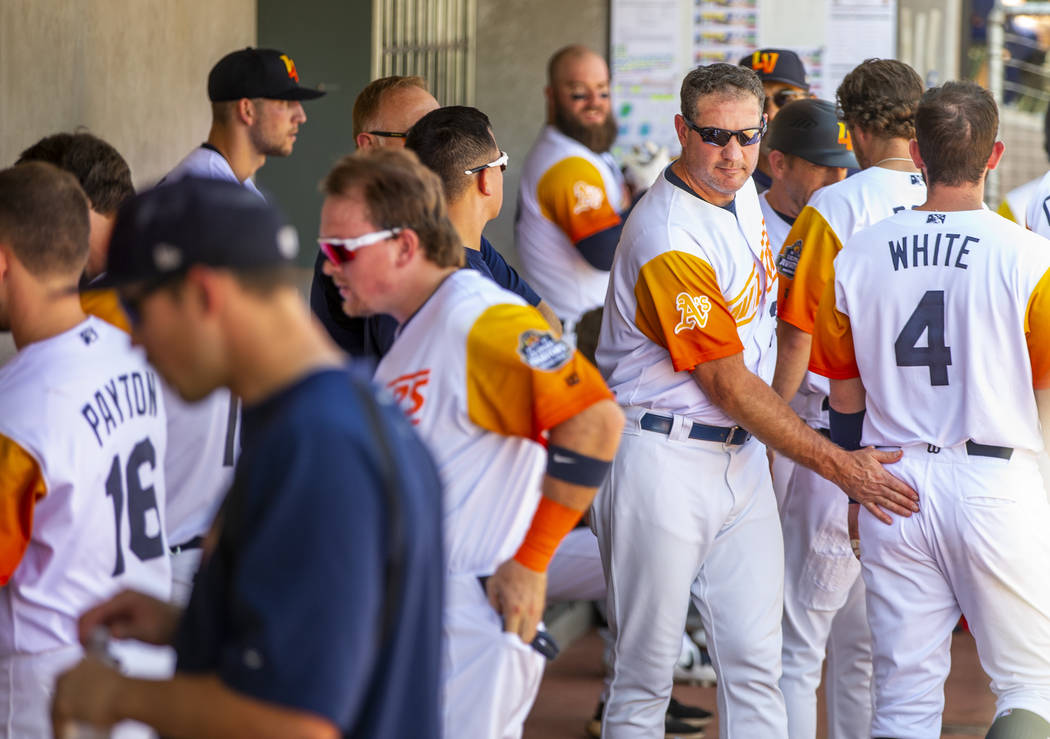 Las Vegas Aviators manager Fran Riordan (39, center) pats player third baseman Mikey White (4) ...