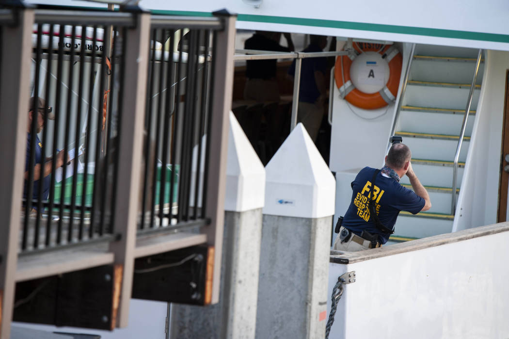 FBI investigators climb aboard the "Vision" a sister vessel to the scuba boat Concept ...