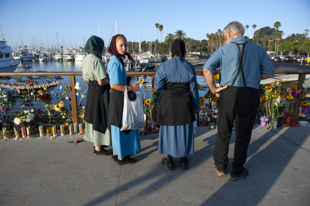 A family from Iowa observes a memorial placed for the victims of Monday's dive boat fire at the ...