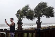 William Ellinge, of Murrells Inlet, S.C., takes photos of waves crashing on the shore in Myrtle ...