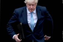 Britain's Prime Minister Boris Johnson walks towards a podium to speak to the media outside 10 ...