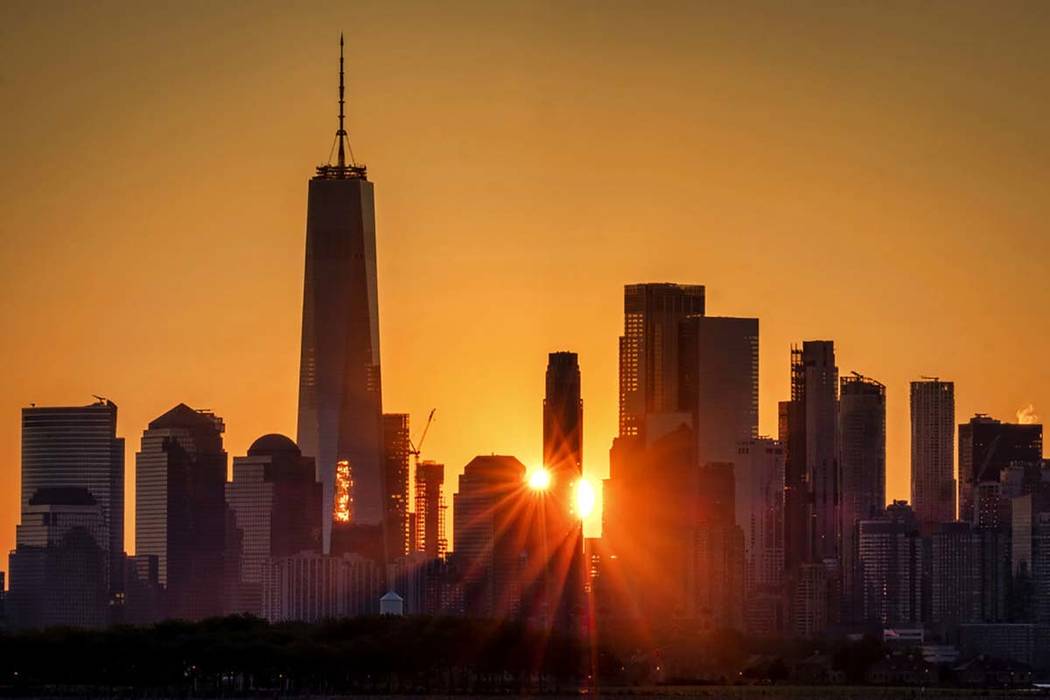 In a July 1, 2019, file photo, the sunlight flares around the buildings in lower Manhattan as t ...
